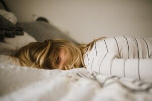 a blonde woman lying on bed